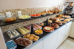 A buffet with various food items and a coffee station.
