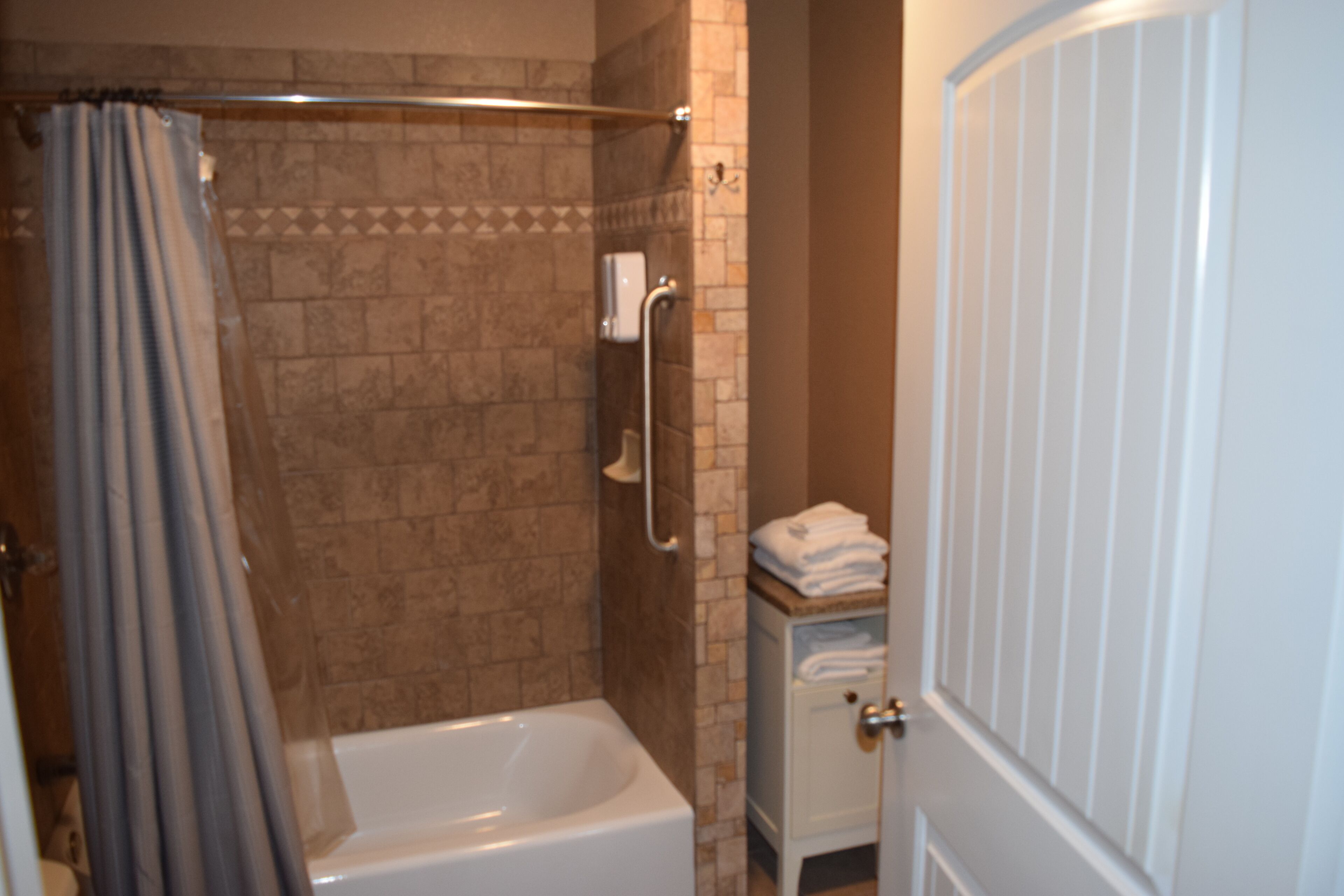 Ein Badezimmer mit Badewanne, Dusche und Handtuchhalter.