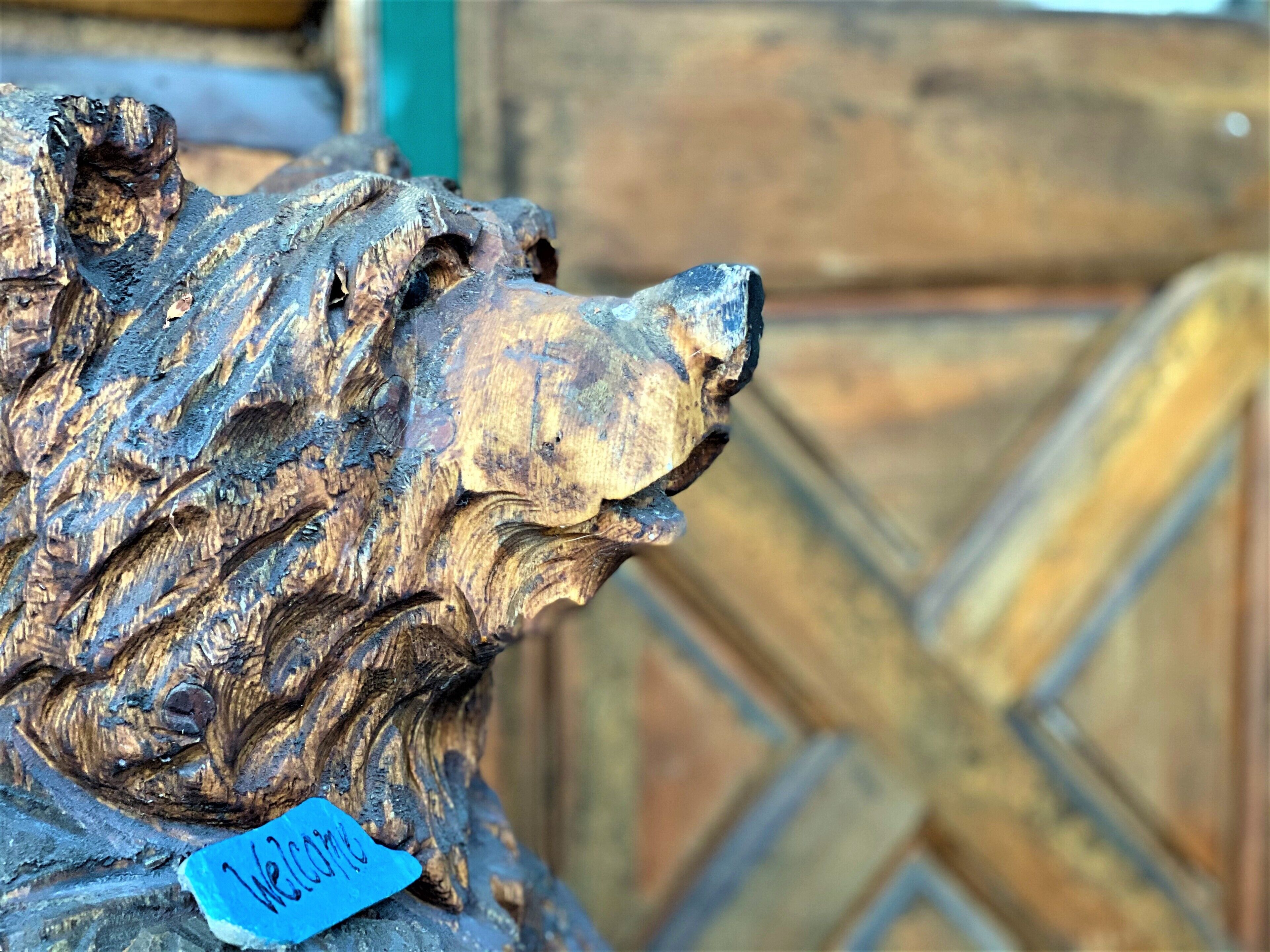 A detailed sculpture of a lion's head with a blue tag labeled "Welcome".