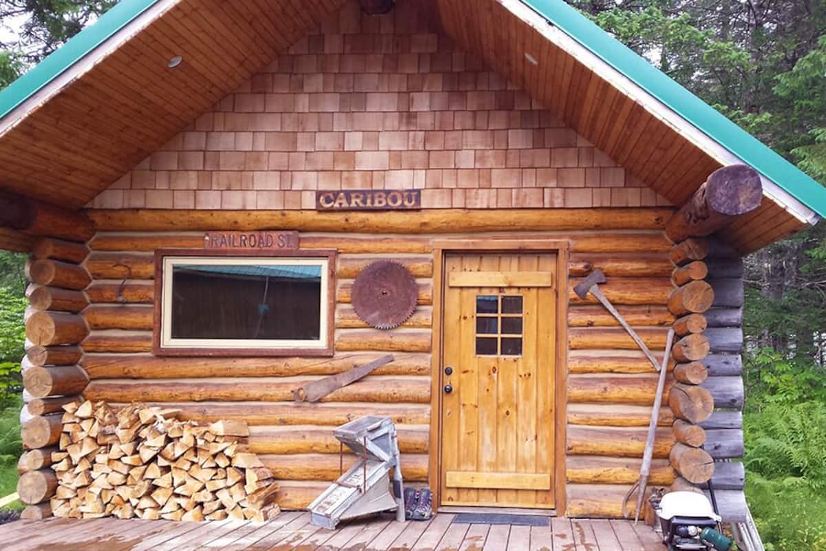 A log cabin with a sign reading "CARIBOU" and "RAILROAD ST."