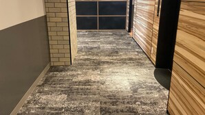 A hallway with a patterned carpet, a brick wall on one side, and wooden paneling on the other. - My Dear II - Adults Only (Osaka)