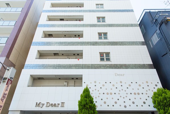 A multi-story building with a sign reading "My Dear II" and a decorative pattern on the facade.