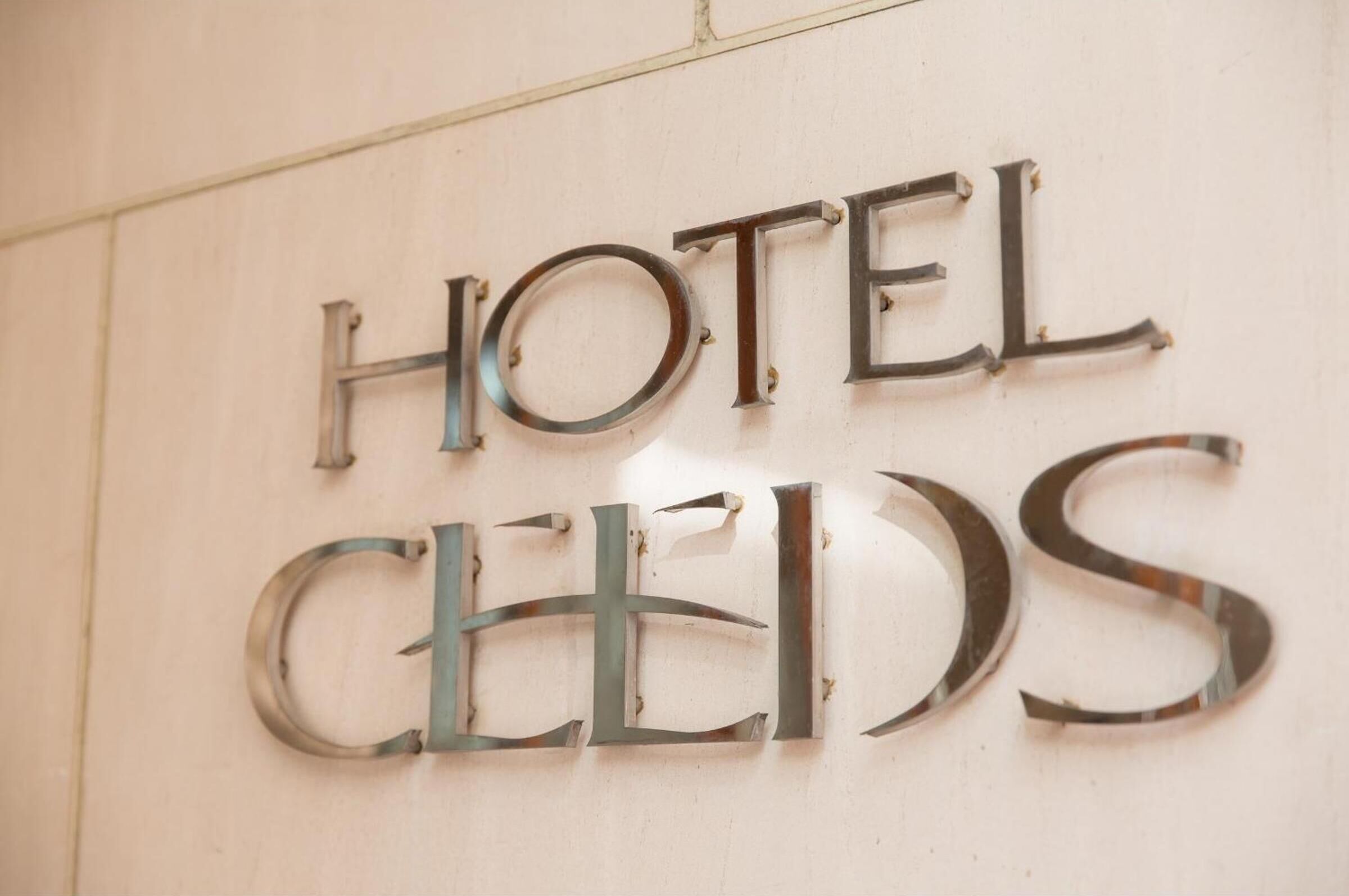 A metal sign with the words "HOTEL" and "CELLS" mounted on a wall.
