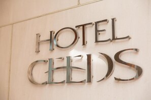A metal sign with the words "HOTEL" and "CELLS" mounted on a wall. - Hotel Ceeds - Adults Only (Osaka)