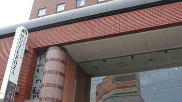 A hotel with a prominent sign reading "HOTEL MONTEROZA" and a large entrance canopy.