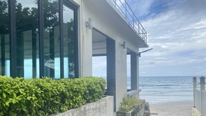A coastal building with large windows, a concrete exterior, and a view of the ocean. - Du Talay Hotel Koh Chang (Ko Chang)