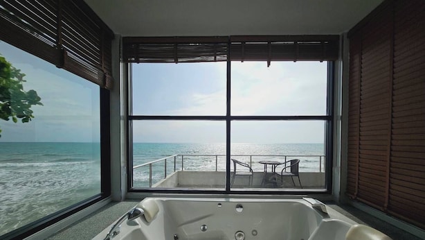 A bathroom with a large window, a bathtub, and a view of the ocean. - Du Talay Hotel Koh Chang (Ko Chang)