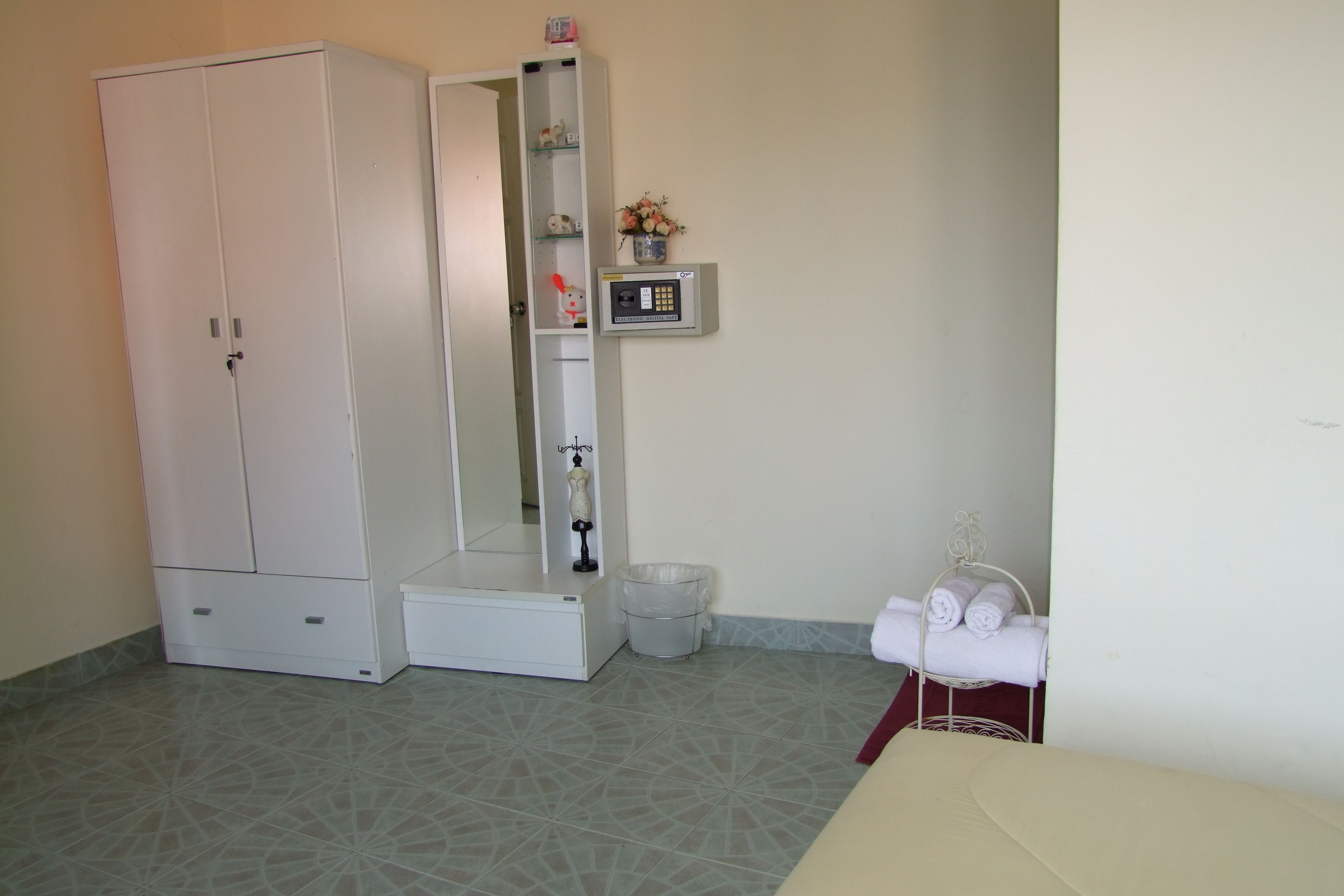 A bathroom with a white cabinet, a shower stall, a toilet, and a towel rack.