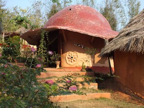 Experience the charm of this traditional building with its distinctive dome-shaped structure and thatched roof entrance.