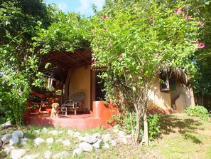Relax in a serene outdoor setting surrounded by lush greenery and flowering plants.