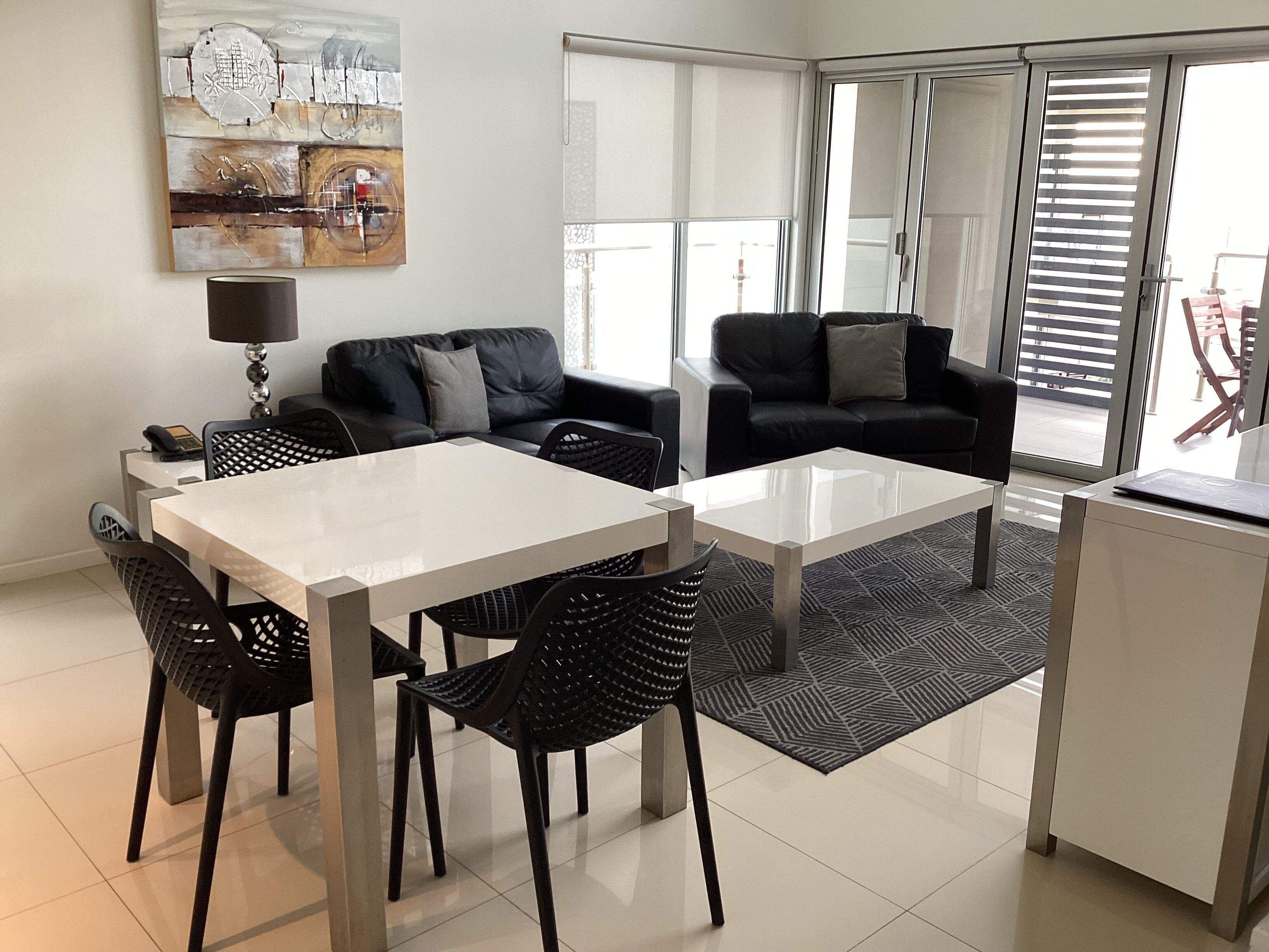 A modern living room with a dining table, two sofas, and a coffee table.