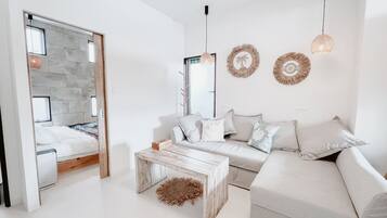 Design Quadruple Room, 1 Queen Bed with Sofa bed | Living area | 50-inch flat-screen TV with digital channels