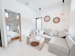 A modern living room with a sofa, coffee table, and decorative wall art. - BeachHouse Geragera (Kobe)