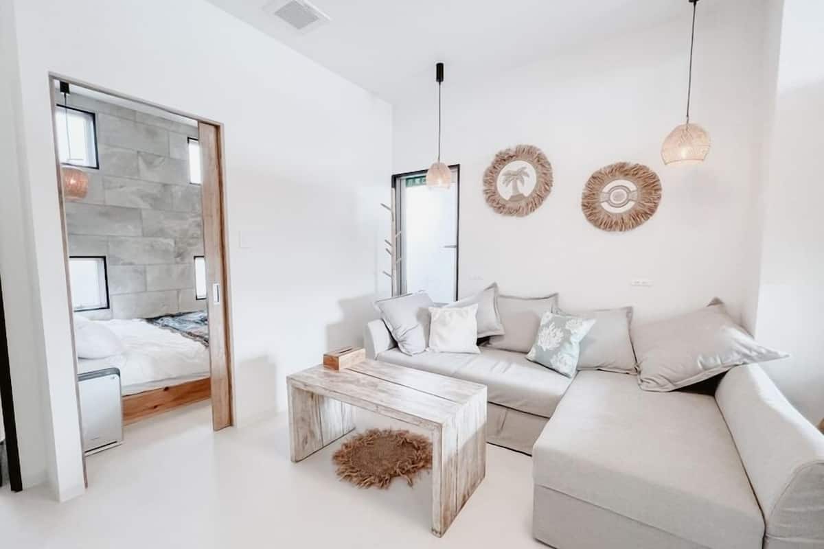 Una sala moderna con sofá, mesa de centro y cama con vistas.
