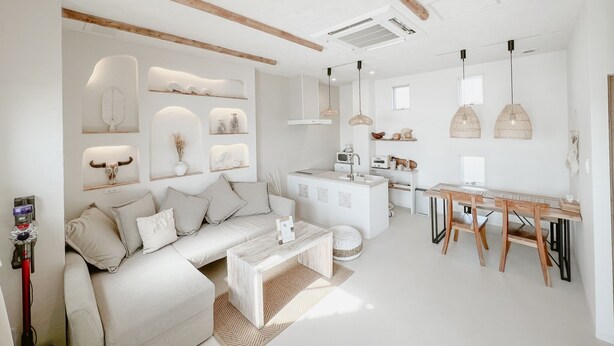 A modern, minimalist living room with a sofa, coffee table, and decorative wall shelves. - BeachHouse Geragera (Kobe)
