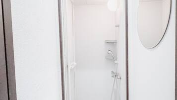 A modern bathroom with a shower, a mirror, and a towel rack.
