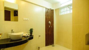 Un baño moderno con un lavamanos grande, un espejo, una ducha y un inodoro.