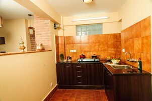 Una cocina con armarios de madera oscura, un lavamanos de acero inoxidable y un salpicadero de azulejos.