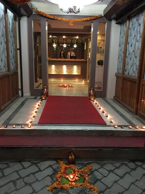 A reception area with a red carpet, a reception desk, and a wall with a sign that reads "RECEPTION". - Festoon Hotel (Kathmandu)
