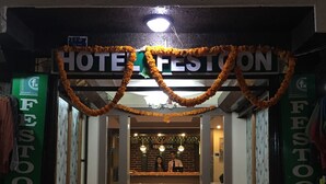 A hotel entrance with a reception desk, a red carpet, and a garland decoration. - Festoon Hotel (Kathmandu)