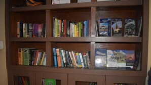 A bookshelf with various books, including travel guides and novels. - Festoon Hotel (Kathmandu)