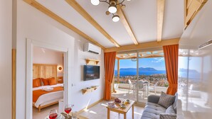A modern hotel room with a balcony, a bed, a dining area, and a sofa. - Hotel Aysima (Kas)