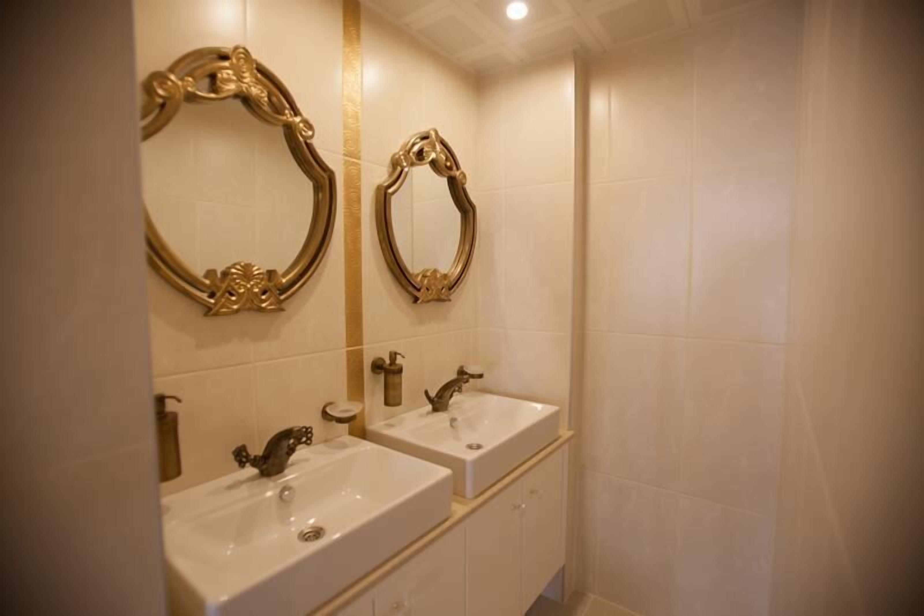 A bathroom with two sinks, a mirror, and a bathtub.