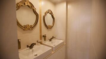 A bathroom with two sinks, a mirror, and a bathtub.