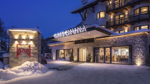 A hotel with a stone facade, large glass windows, and a sign reading "GRISCHUNA". - Heart Hotel Grischuna  (Sankt Anton am Arlberg)