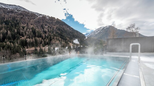 A swimming pool with a view of a mountainous landscape. - Heart Hotel Grischuna  (Sankt Anton am Arlberg)