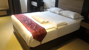 Una habitación de hotel con cama, escritorio y teléfono.