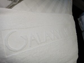 Una toalla blanca con el texto grabado “GALAXY HOTEL”.