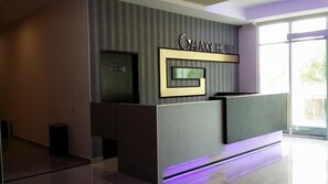 A modern hotel reception area with a 'CANY HOTEL' sign, a staff-only door, and a glass partition. - Galaxy Hotel (Simpang Ampat)