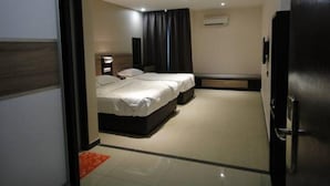 Quarto de hotel com cama, mesa de cabeceira e aparelho de ar condicionado.