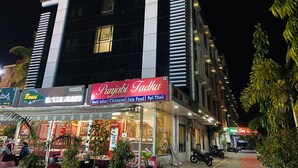 Un hotel con un cartel que dice 'Hotel Sai Bansi' y un restaurante llamado 'Punjabi Tikka' que ofrece comida del sur de la India, china y Jain.