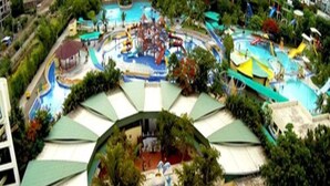 A water park with multiple slides and pools, surrounded by green umbrellas and trees. - Hotel Sai Chhatra (Rahata)
