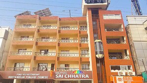 A multi-story hotel with balconies, a restaurant, and solar panels. - Hotel Sai Chhatra (Rahata)