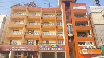 A multi-story hotel with balconies, a restaurant, and solar panels.