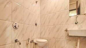 A bathroom with a toilet, shower, and sink. - Hotel Sai Chhatra (Rahata)