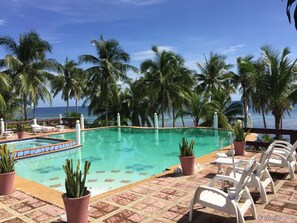 Een buitenzwembad en ligstoelen