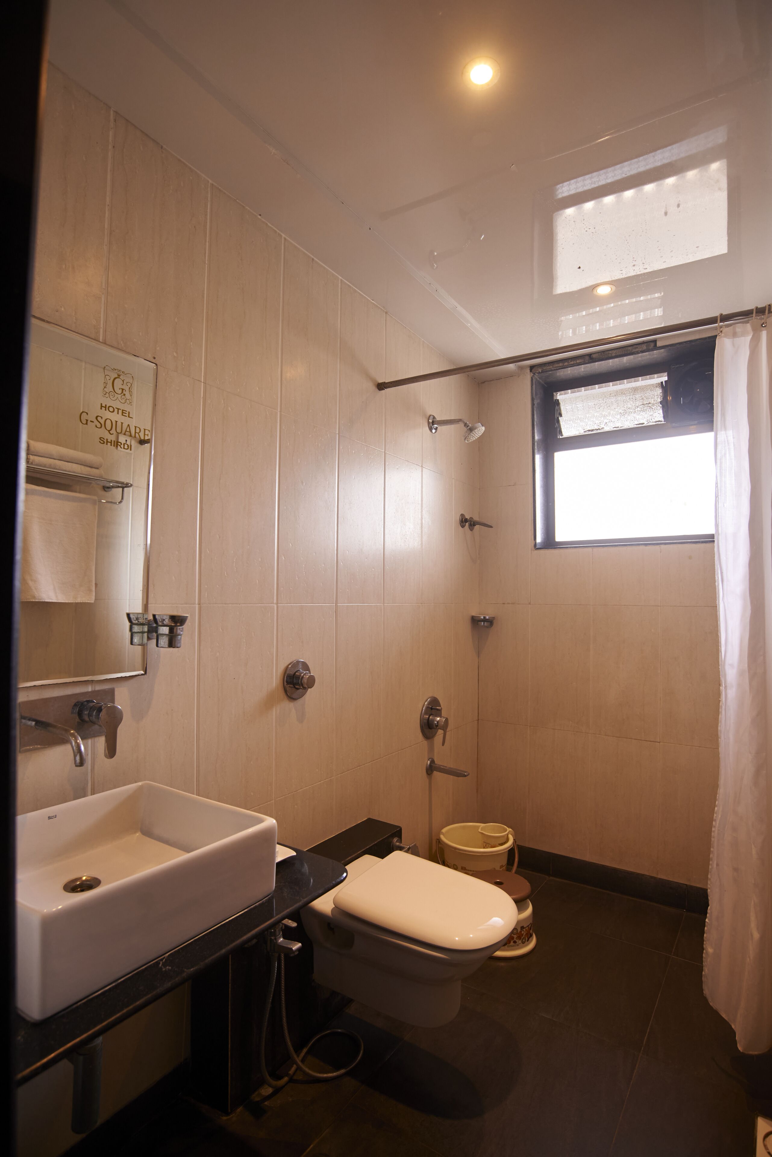 Une petite salle de bain comprenant des toilettes, un lavabo et une douche.