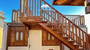 A wooden staircase leading to a door with a small window, part of a building with a white exterior and wooden accents. - Green Garden Resort (Hurghada)