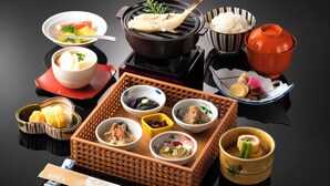 Une variété de plats japonais présentés sur une table, notamment des sushis, du riz et d’autres accompagnements.