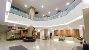 A spacious lobby with a reception desk, seating area, and a staircase leading to an upper level. - Hotel 88 Mangga Besar 62 by WH (Jakarta)