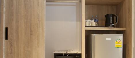 Un armario de madera con una cama, un refrigerador y un microondas.