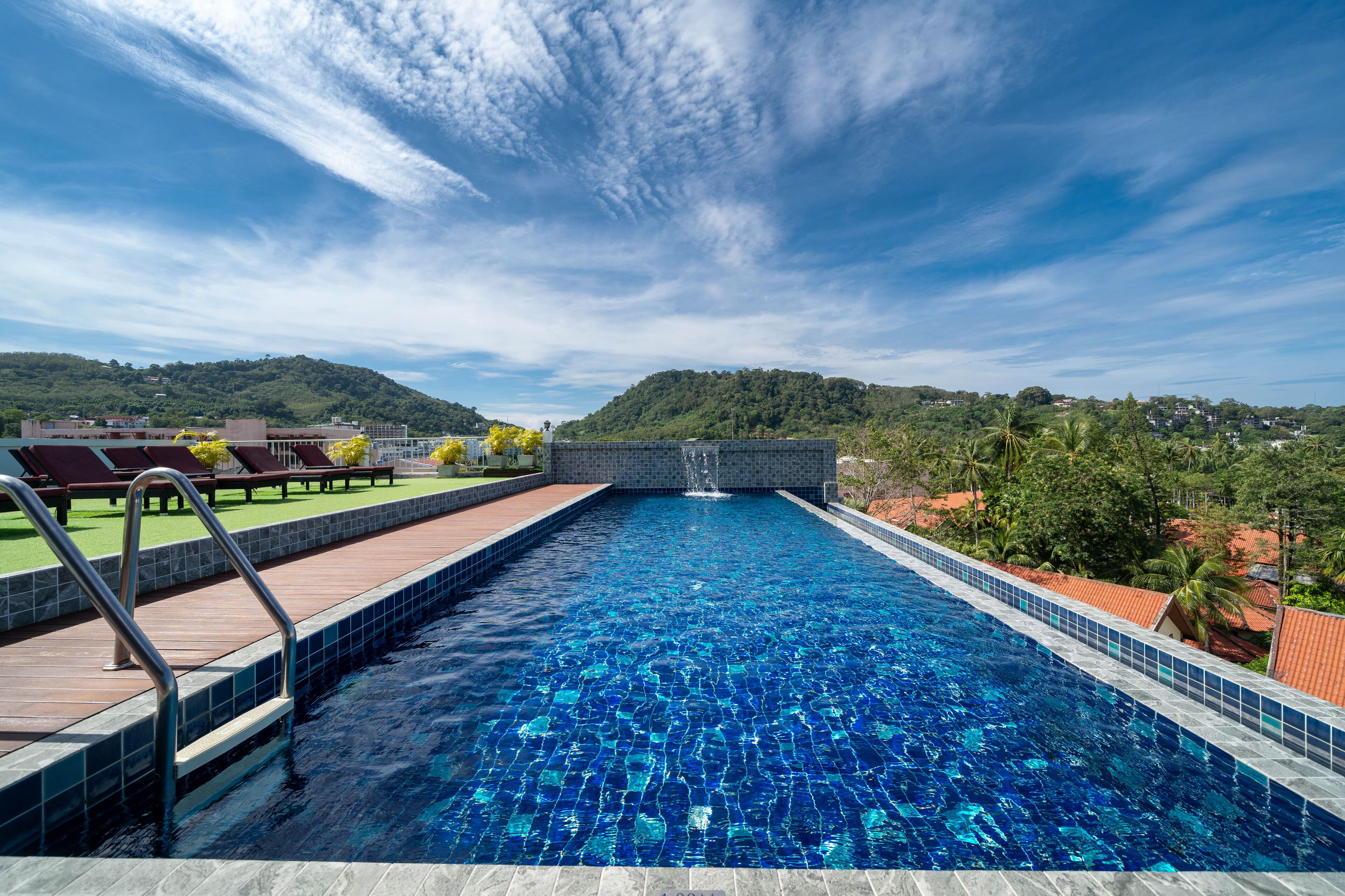 A swimming pool with a view of hills and a clear sky.