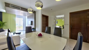 Un comedor moderno con una mesa blanca, sillas negras y un cuenco decorativo.