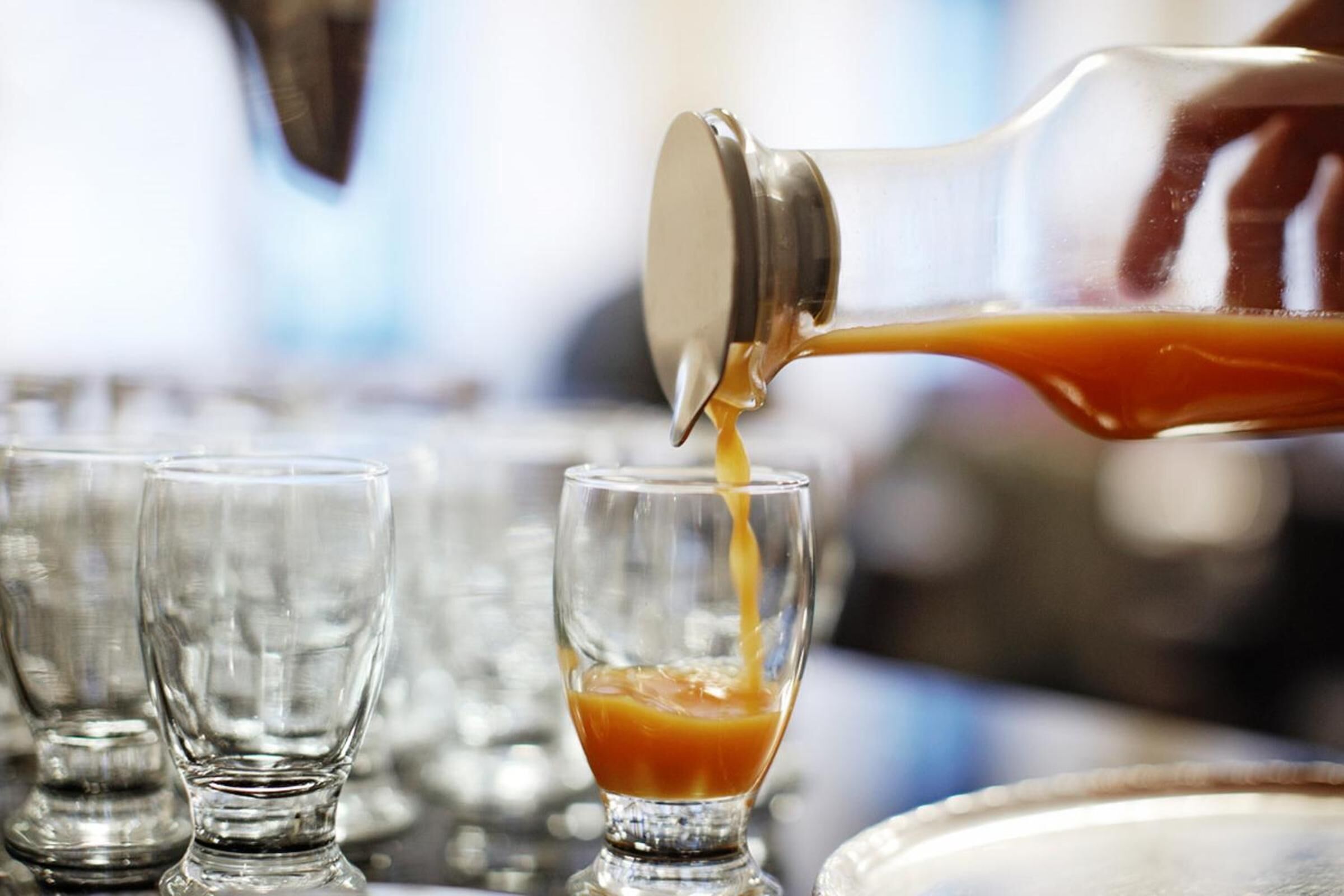 A cocktail being poured into a glass.