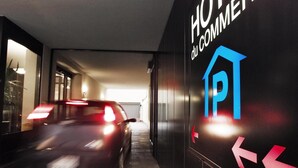 A modern hotel entrance with a sign indicating "HOTEL du COMMET" and directional arrows on the wall. - Congress Apartments by Hotel du Commerce (Basel)