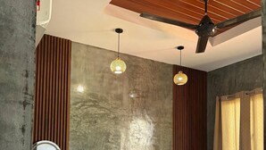 A bedroom with a bed, a ceiling fan, a wall-mounted mirror, and a window with curtains. - Corrie Chalet Pantai Cenang Langkawi (Langkawi)